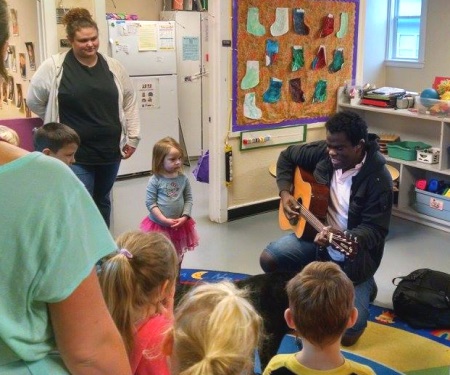 George Stern plays his guitar in front of a group of preschool-aged children.