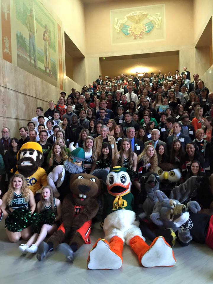 Hundreds of Oregon university students stand on the stairs in the Capitol Rotunda.